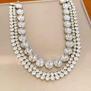 Close-up detail of a multi-layered rhinestone necklace with round crystal clusters.