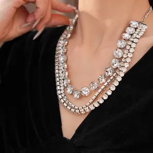 Detailed shot of a luxury three-layer silver necklace decorated with round clear crystals