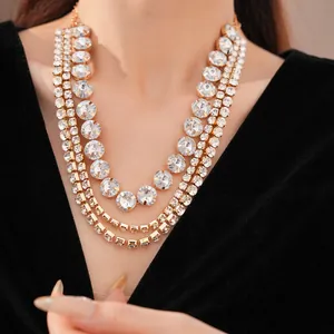 Detailed close-up of a luxurious multi-layer gold necklace with sparkling round crystals