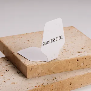 Close-up of a white folded jewelry card with Stainless Steel print on stone