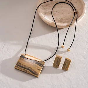 Detailaufnahme einer Vintage-Halskette mit Harzanhänger und passenden Ohrringen