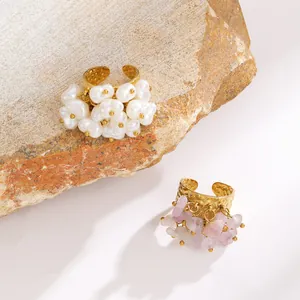 Detailed view of bohemian style gold hammered rings with baroque pearls and pink crystals