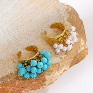 Detailed macro view of bohemian gold rings featuring turquoise and white pearl clusters