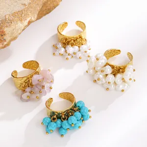 Detailed view of Bohemian gold rings featuring turquoise, pearl, and stone charms.