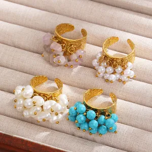 Close-up of bohemian style adjustable gold rings with turquoise and pearl cluster charms