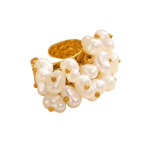 Macro detail of a vintage bohemian style gold ring featuring clustered white baroque pearls.