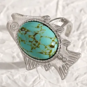 Macro view showing textures of a vintage bohemian fish ring with an oval turquoise stone