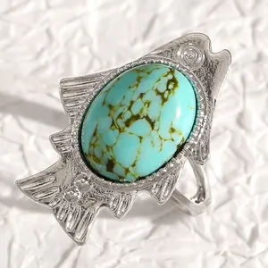 Detailed macro view of bohemian silver fish ring featuring a large oval turquoise stone inlay
