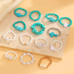 Detailed close-up of Bohemian turquoise and pearl beaded ring set on a stone slab