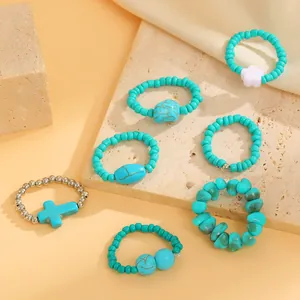 Detailed view showing several bohemian turquoise bead rings with various charm designs
