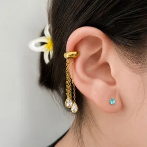 Close-up of elegant gold stainless steel ear cuff with sparkling crystal tassel drops