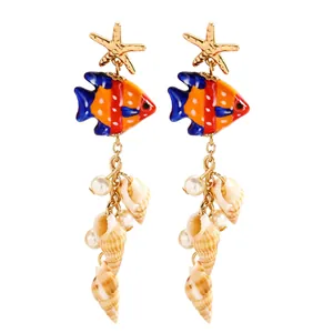 Détail de boucles d'oreilles poisson tropical avec étoile de mer et pampilles