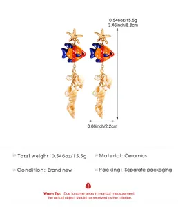 Détails des boucles d'oreilles poisson en céramique avec coquillages et dimensions.