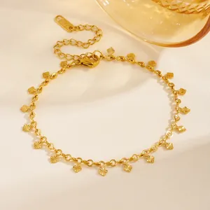 Détail macro d'un bracelet en acier inoxydable plaqué or 18 carats avec breloques losanges