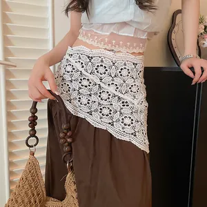Detailed shot of white bohemian crochet lace triangular waist wrap over brown pants