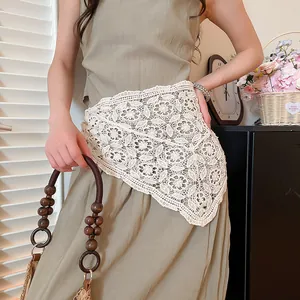 Detail shot of a white hollow crocheted lace triangle shawl styled as a chic waist accessory