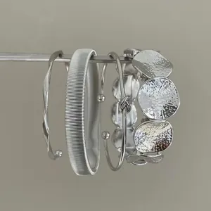 Set di bracciali rigidi in metallo irregolare argento con design minimalista
