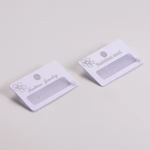 Macro view of white matte PVC earring display cards featuring flower patterns and text labels