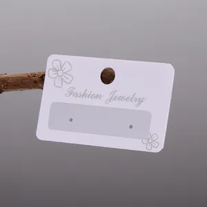 Close-up of white PVC earring display card with elegant floral pattern and matte finish