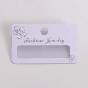 Detail view of white frosted PVC earring display card with silver floral pattern