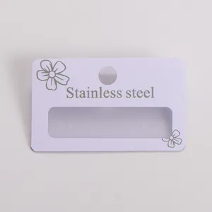 Detail of white PVC earring display card with "Stainless steel" silver printing.