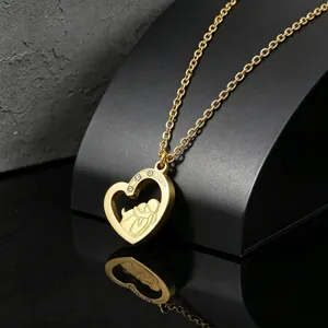 Detail view of gold stainless steel heart pendant with mother and child engraving