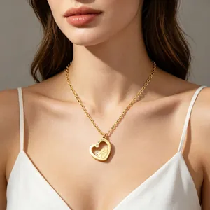Close-up of golden hollow heart pendant necklace with mother-child design on model