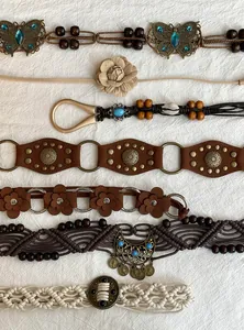Macro detail of various Bohemian ethnic belts featuring suede flowers, beads and turquoise stones.