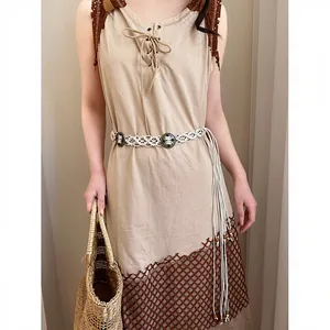Bohemian white hand-woven belt with ethnic metal accents on brown Maillard dress.