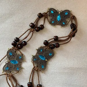 Bohemian brown woven belt detail with wooden beads and blue butterfly crystal accents