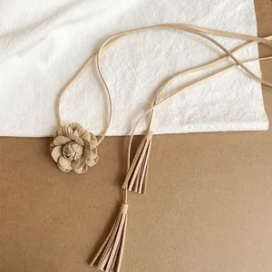 Detailed close-up of a camel faux suede flower waist chain featuring tassels and ethnic style