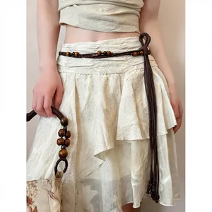 Detail view of bohemian brown woven belt with decorative wooden beads and tassels