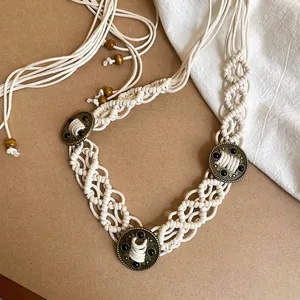 Detailed view of a bohemian macrame waist chain featuring vintage bronze buckles and wooden beads.