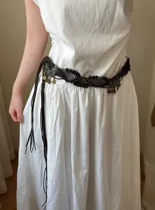 Bohemian ethnic woven waist chain belt with turquoise beads shown on a white dress