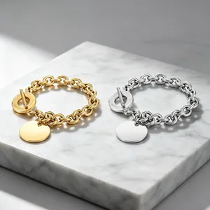 Two titanium steel O-chain bracelets in gold and silver with polished disc charm