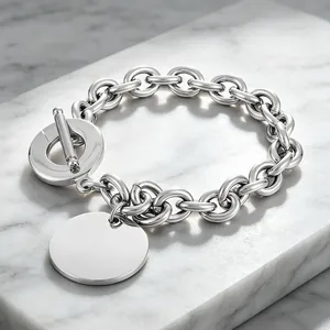 Detailed view of polished round pendant and OT toggle clasp on a titanium steel bracelet