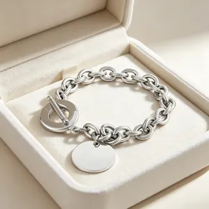 Detailed view of titanium steel OT buckle bracelet with polished round pendant in box
