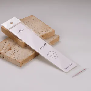 Macro detail of white jewelry display card with protective OPP packaging bag.