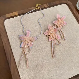 Elegant French style jewelry set featuring pink fabric flowers and beaded tassels on a tray