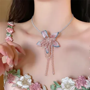 Detailed view of a French-style floral necklace with long beaded tassels on model.