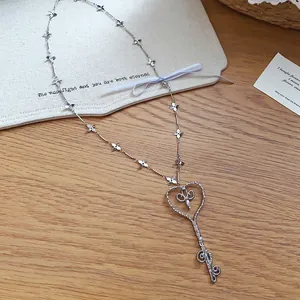 Vista detallada del collar con colgante de llave en forma de corazón de plata y flores