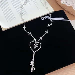 Detalle de collar con colgante de llave de corazón plateado con perlas y flores