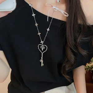 Primer plano de un elegante collar con colgante de llave de corazón usado por un modelo