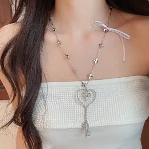 Detalle de un collar coreano con colgante de llave de corazón y cinta blanca decorativa