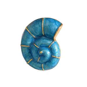 Nahaufnahme einer blauen nautilus Muschel-Brosche mit goldenen Rändern im Retro-Stil