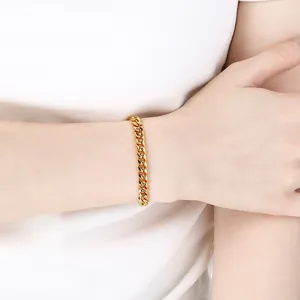 Dettaglio ravvicinato di un bracciale a catena cubana in acciaio inossidabile dorato lucido