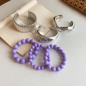 Detailed macro shot of vintage silver metallic bangles and purple beaded bracelet set