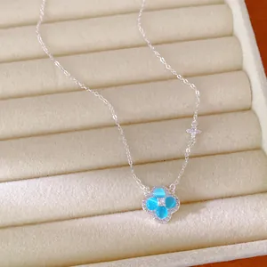 Gros plan d'un collier en argent élégant avec pendentif trèfle à quatre feuilles bleu