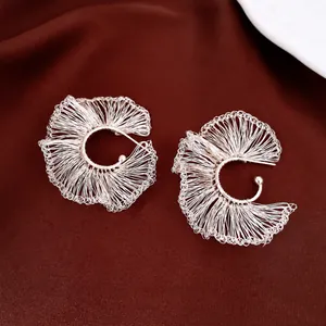 Pendientes artesanales de plata tejidos a mano con diseño de abanico sobre tela roja