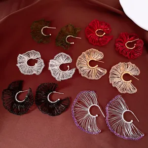 Detalle de varios colores de pendientes de flores tejidas a mano con agujas de plata fina.